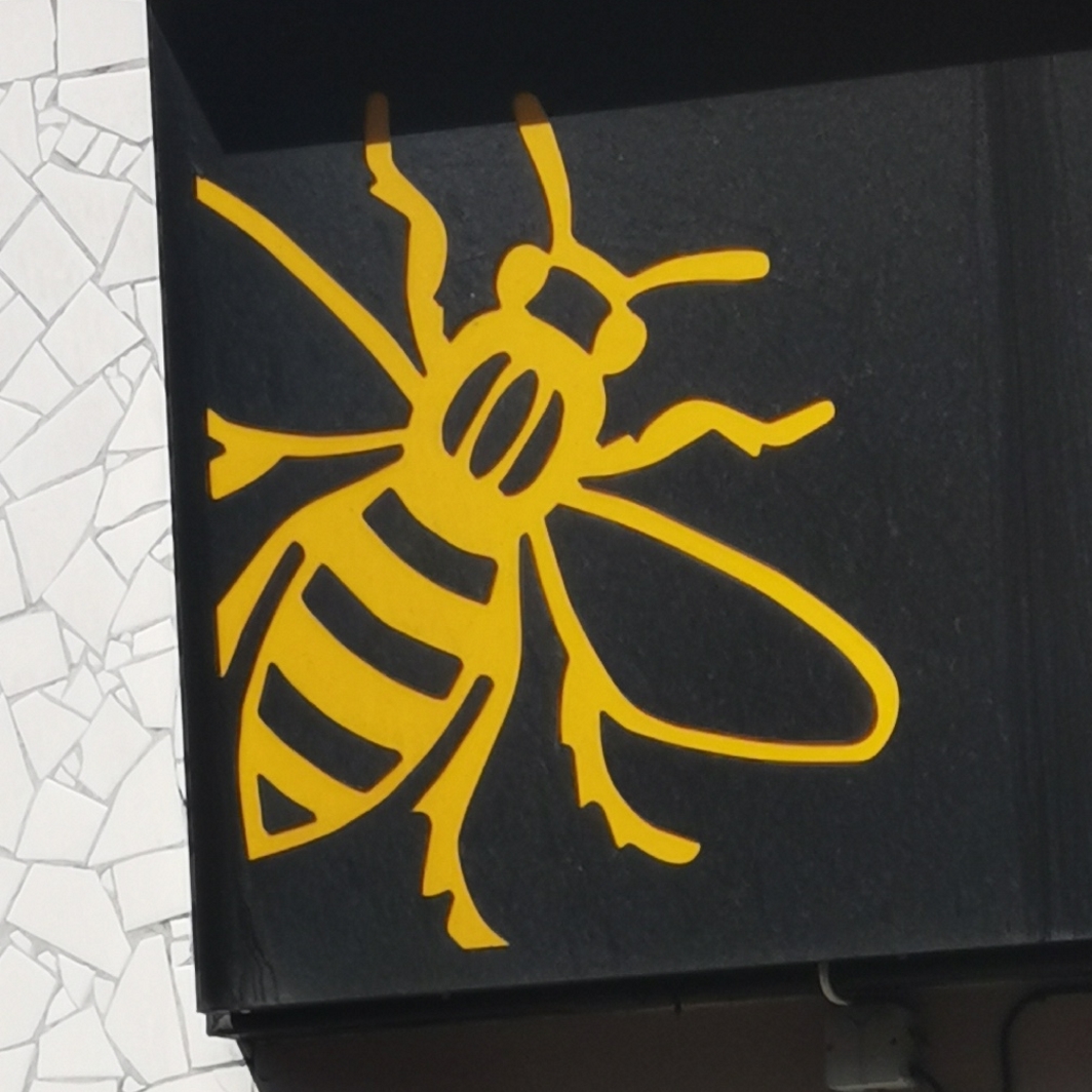 Bee on signage at The Manchester Shop, Oldham Street