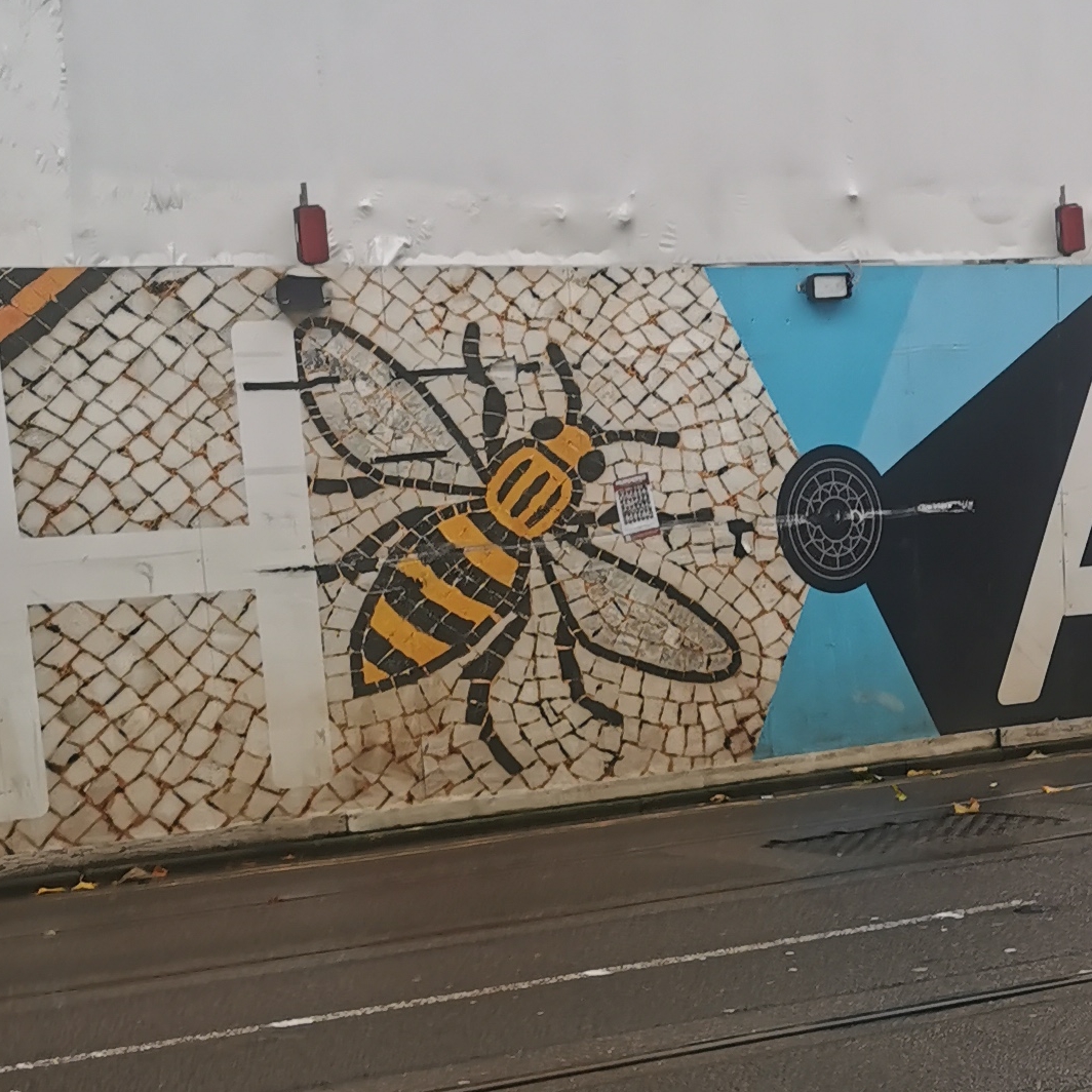 Manchester mosaic bee on construction hoarding near Town Hall