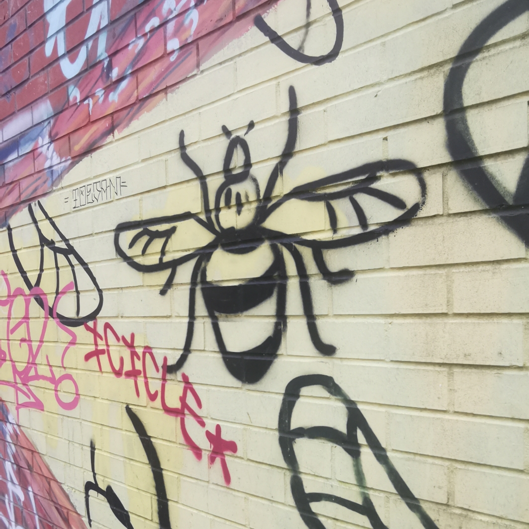 Graffiti bees on building Bridgewater Canal Tow path near Hulme Hall Road